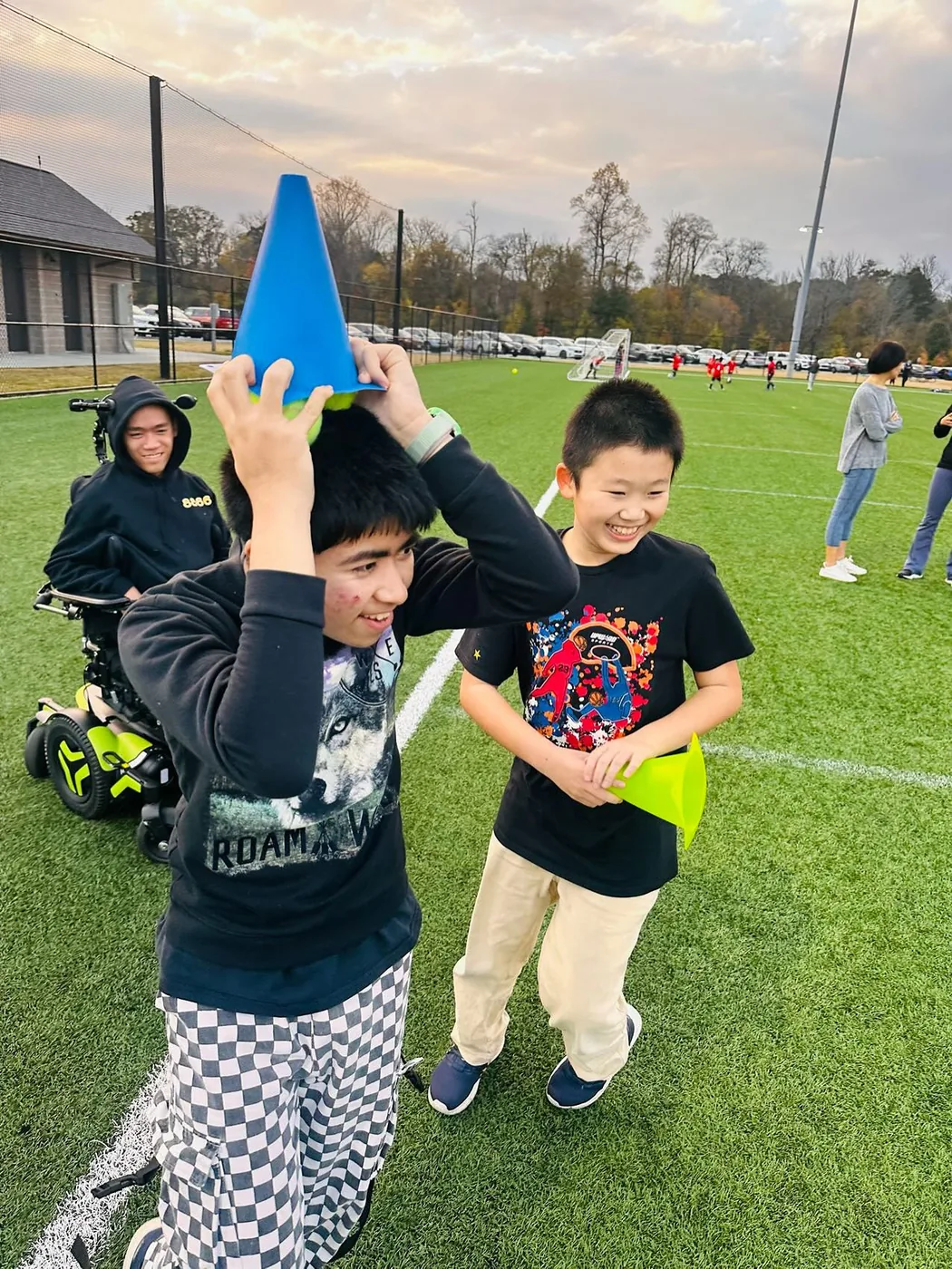 Participants smiling during a field activity with colorful cones