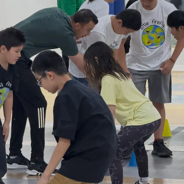Little Firefly participants and a coach gathered during a fencing activity