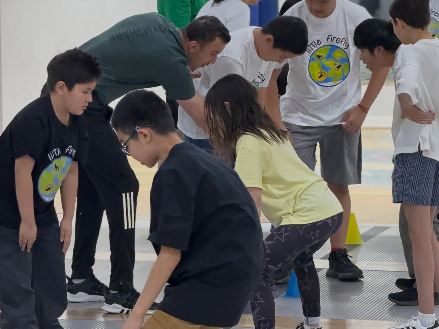 Little Firefly participants and a coach gathered during a fencing activity