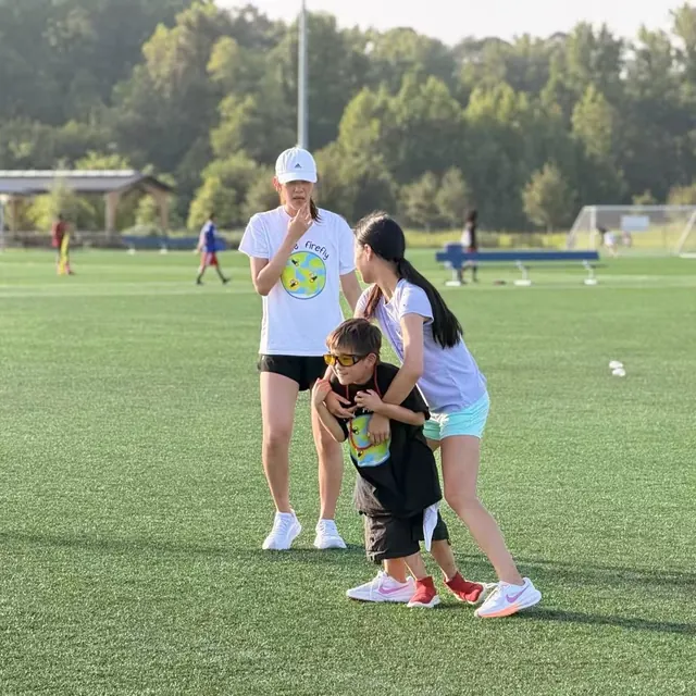 Youth volunteers supporting a participant during a field activity