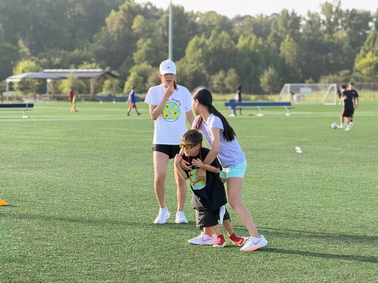 Youth volunteers supporting a participant during a field activity