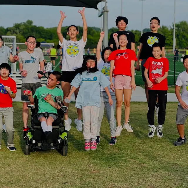 Little Firefly participants and volunteers celebrating together on an outdoor field