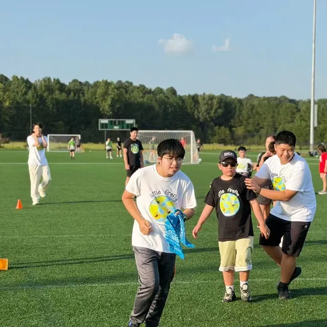 Participants and youth volunteers moving through an outdoor relay