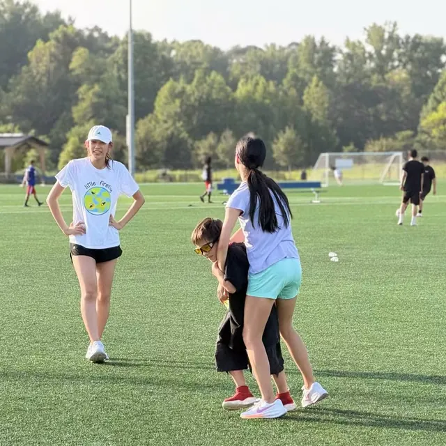 A youth volunteer supporting a participant during a field activity
